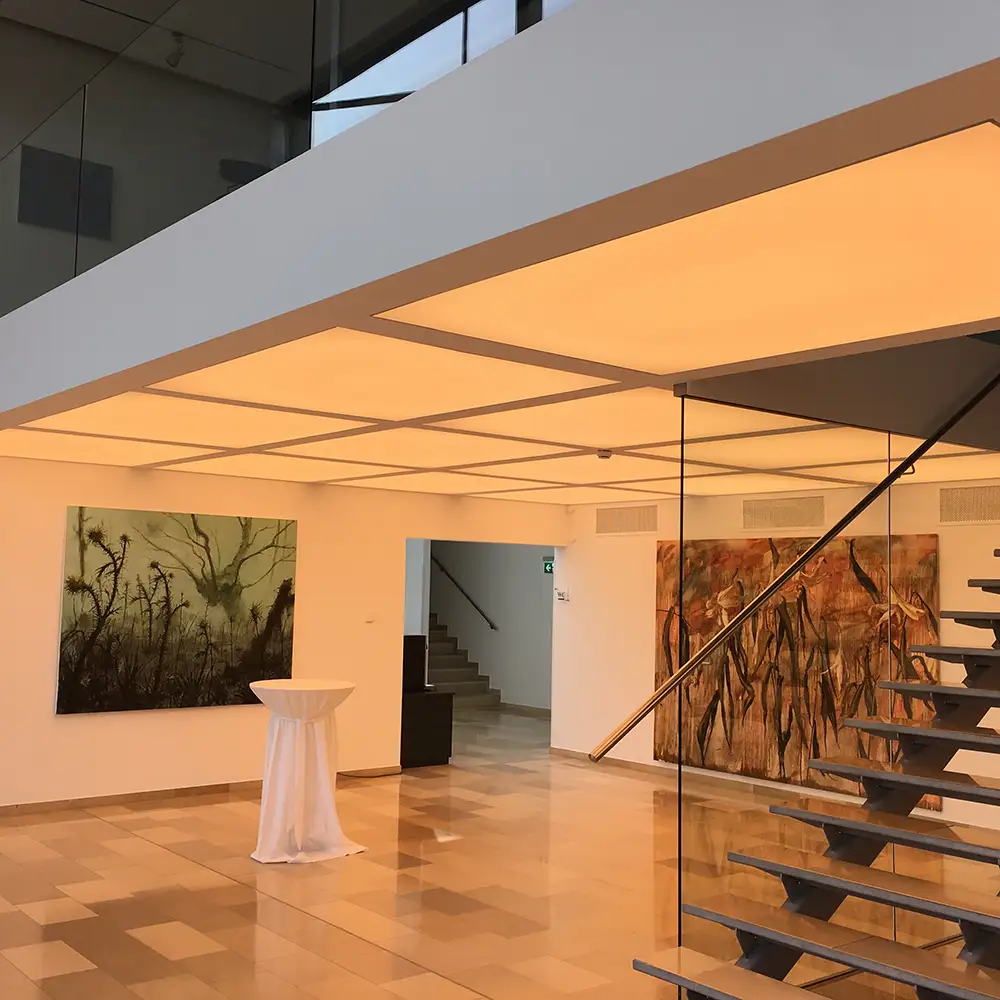In einer Ausstellung wurde als Beleuchtung eine Lichtdecke in warmweiß in Feldern aufgeteilt und an den Boden angepasst.